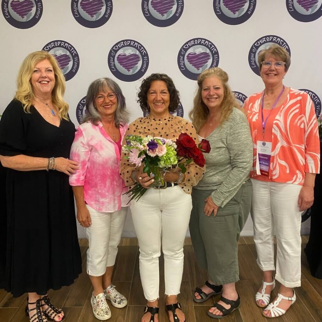 5 women in front of a League of Chiropractic Women backdrop